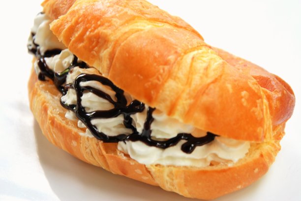 新鲜奶油和热巧克力的甜羊角面包图片下载