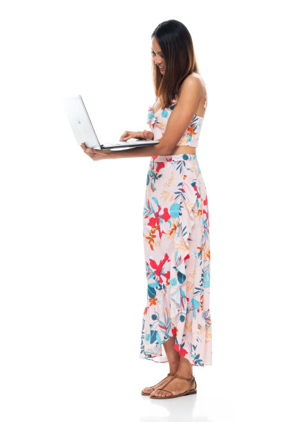 女性穿着裙子站在白色背景前使用电脑图片下载
