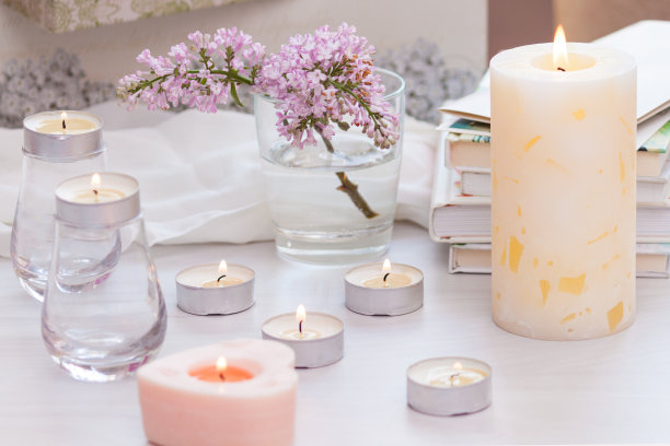 色彩柔和的室内装饰，燃烧的手工蜡烛，书籍，鲜花。舒适、放松的概念。图片下载