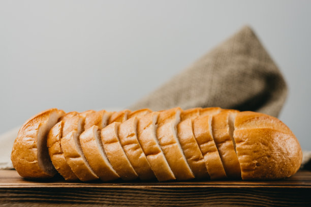 小麦面包，在木板上切成长条。图片下载