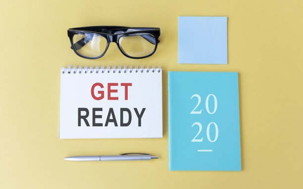 办公场所，计算器，文具，明亮的笔记本和眼镜。JET READY文本在白色笔记本页上。黄色背景俯视图，平铺图片下载