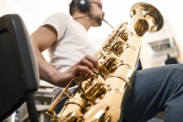 年轻人吹萨克斯管，专注于手指图片下载