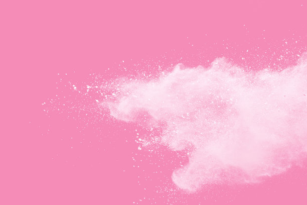 摘要白色粉末爆炸。特写的白色尘埃颗粒飞溅孤立在粉红色的背景。图片下载