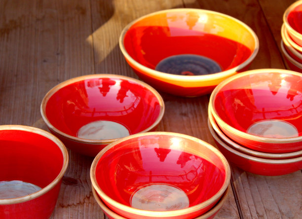 木质表面上的红色陶碗图片下载