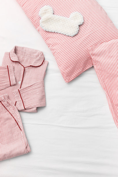 睡衣睡衣，蓬松的睡眠眼罩，枕头和有复印空间的白色床单上的毯子。前视图。平的。图片下载