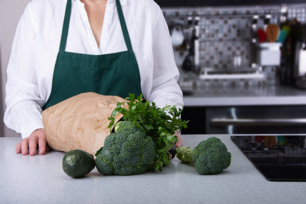 装满绿色蔬菜的棕色纸袋准备烹饪。图片下载