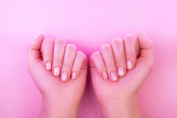 女性的手与完美的美甲在时髦的霓虹灯粉红色的背景。图片下载