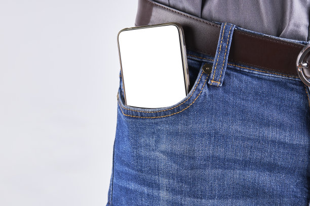 在牛仔裤口袋前放手机的男性。空的显示模型。图片下载