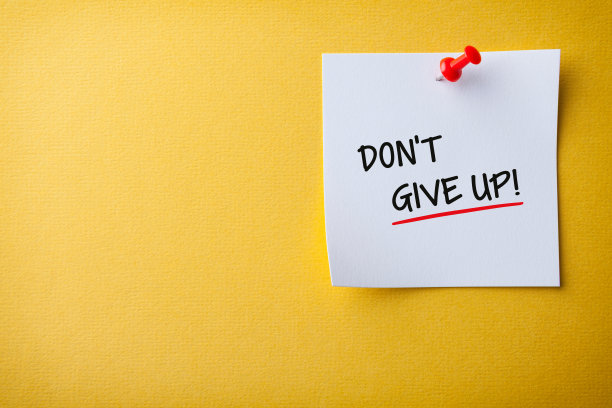 白色便利贴与不放弃和红色推针在黄色背景图片下载