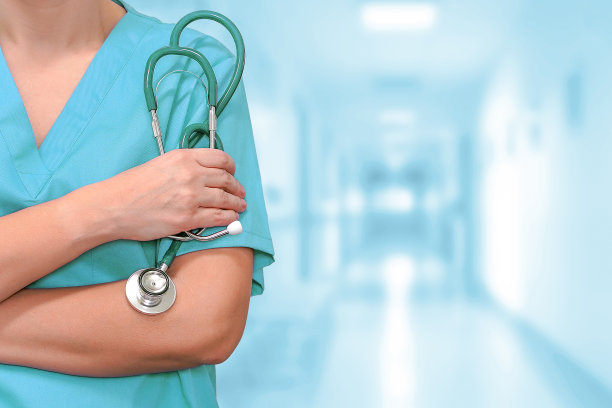 诊所走廊手持听诊器的女医生图片下载