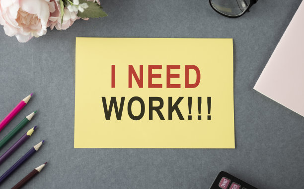 我需要一张黄牌上的工作文字。灰色背景与办公用品。图片下载