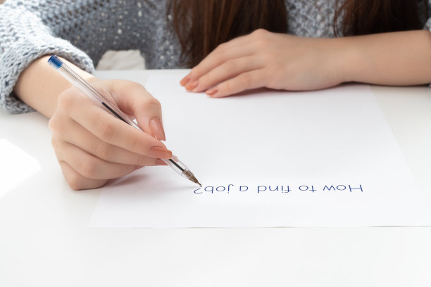 金融崩溃和失业。女性的手在一张纸上写下如何找工作图片下载