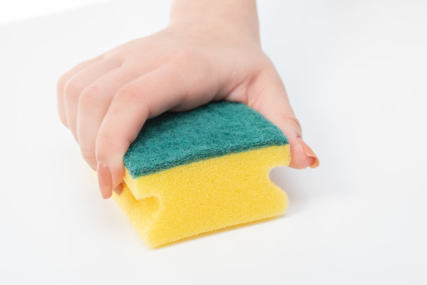 打扫公寓、办公室、别墅、仓库、车库。女性的手用黄色海绵擦拭白色的表面图片下载