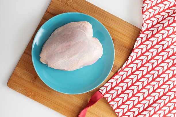 做健康饮食汤。生鸡胸肉放在桌上一个蓝色的盘子里图片下载