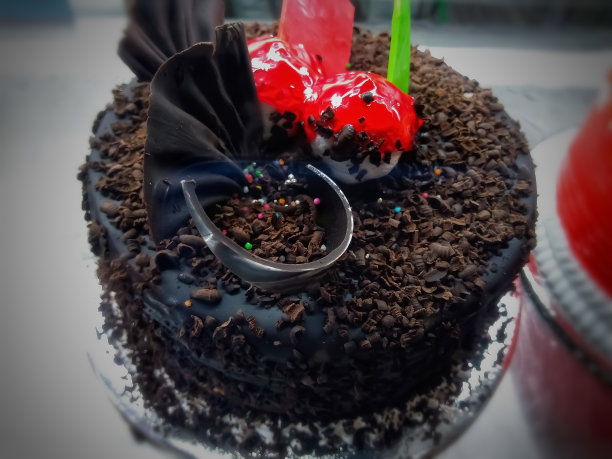 美味的巧克力蛋糕，上面有新鲜的草莓，覆盆子，蓝莓，加仑子，开心果，糖果和奶油。图片下载