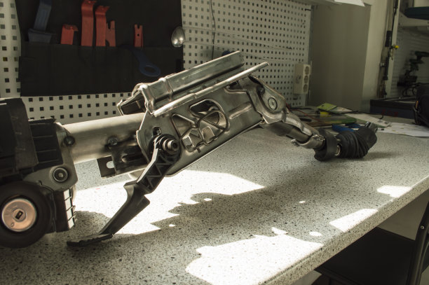 一段汽车转向柱的碎片躺在桌子上，照片倾斜着。图片下载