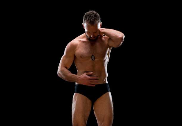 白人男性穿着内衣站在黑色背景前图片下载
