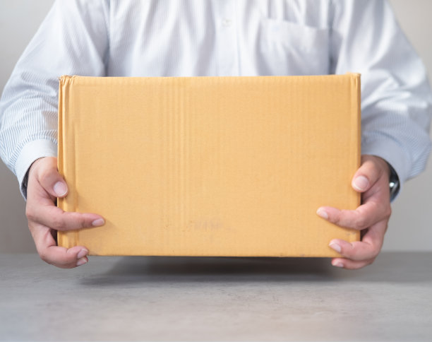 快递员拿着纸板箱。快速免费送货运输。网上购物和快递。图片下载