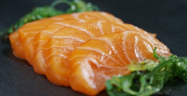 寿司，生鱼片，浦城和夜拍的微距镜头。这是一道典型的日本菜，以米饭、鲑鱼或金枪鱼、虾和鱼卵为背景，配以黑色图片下载