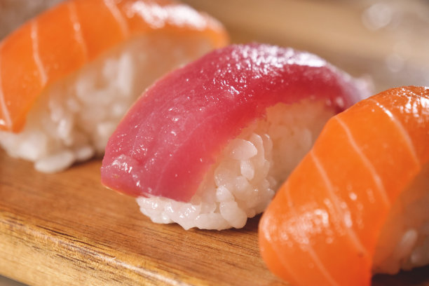 寿司，生鱼片，浦城和夜拍的微距镜头。这是一道典型的日本菜，以米饭、鲑鱼或金枪鱼、虾和鱼卵为背景，配以黑色图片下载