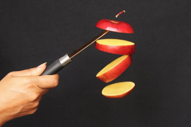 手握刀切飞红苹果图片下载