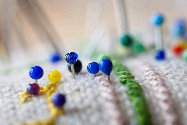 彩色大头针插在针垫里的微距特写图片下载