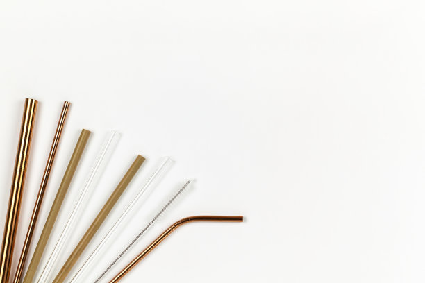 从环保可重复使用的金属管到一次性塑料管。替代一次性餐具的概念。白色背景。水平的。副本的空间。平躺，特写，俯视图图片下载