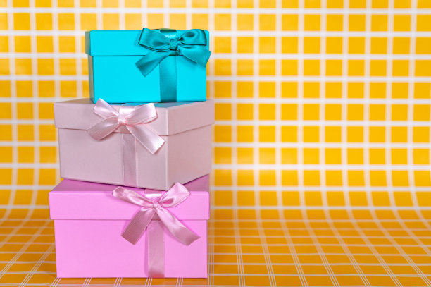 三个礼品盒堆叠在黄色方格背景照片图片下载