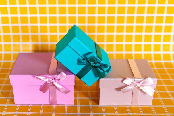 三个礼品盒上的黄色方格背景照片图片下载