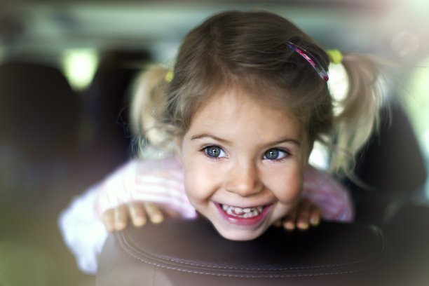 快乐的孩子有乐趣在汽车后座。图片下载