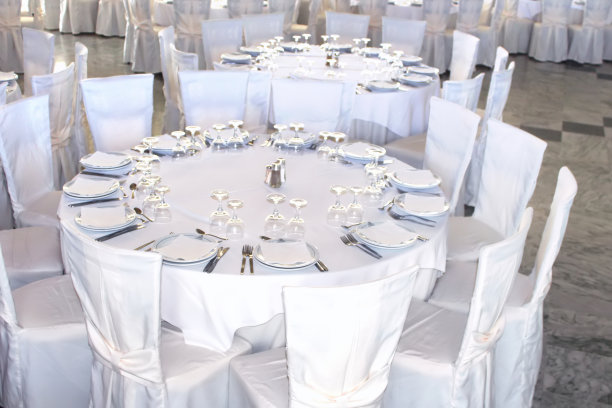 铺着白色桌布的圆桌和铺着白色台布的椅子。宴会的一切都准备好了图片下载