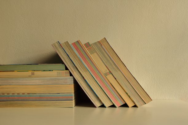 一排斜靠着的书，有阳光和阴影图片下载