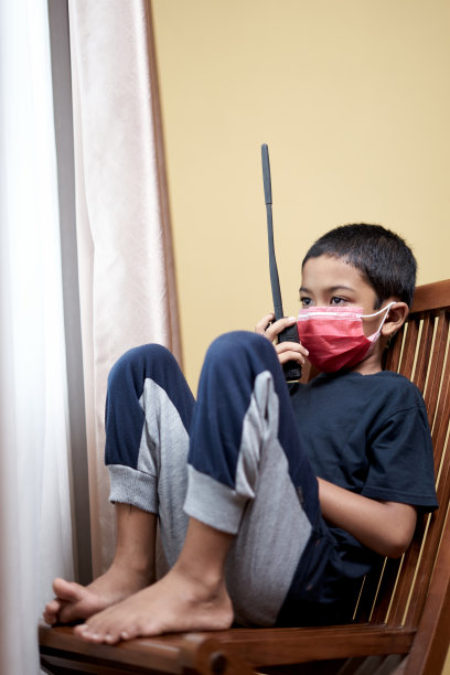 男孩用对讲机和透过家庭隔离窗口进行交流图片下载