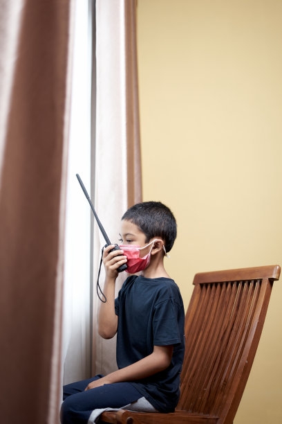 男孩用对讲机和透过家庭隔离窗口进行交流图片下载