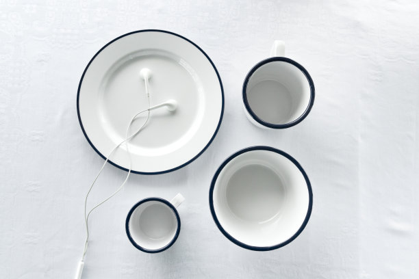 白色碟型吹杯带耳机，用于听音乐，织物桌布，食物或菜肴的背景图片下载