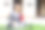 拿着书的女学生在大学大楼附近的草地上竖起大拇指。图片下载