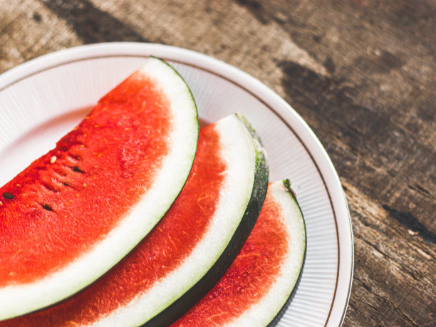 切片西瓜在白色盘子与勺子和叉子股票照片与白色背景。图片下载