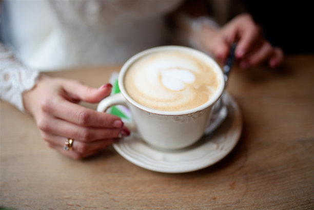 手里拿着一杯卡布奇诺图片下载