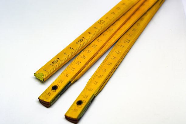 黄色木制折叠米尺与黄铜结束孤立在白色背景图片下载
