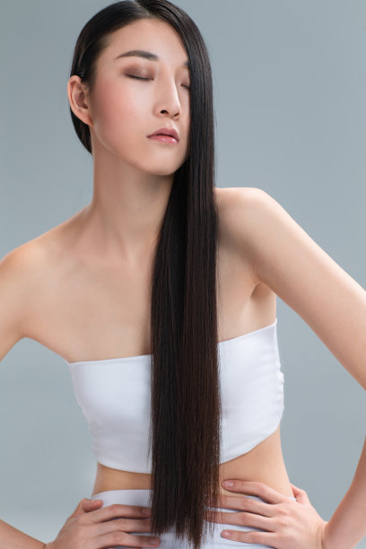 青年女人展示亮丽丝缎般的头发图片下载