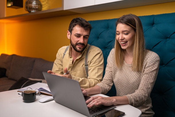 微笑的夫妇在家里一起工作图片下载