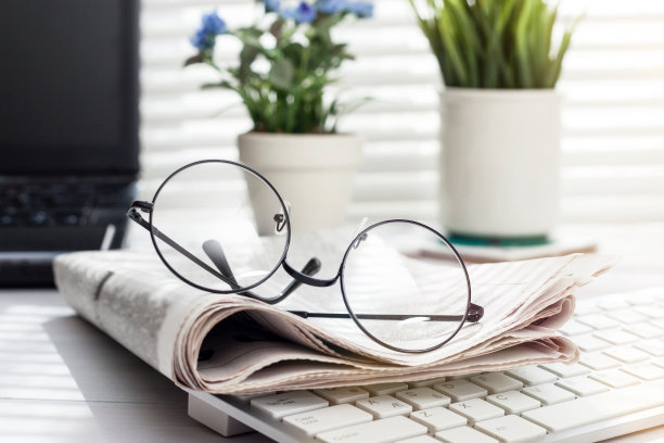 书桌上放着报纸和眼镜素材图片