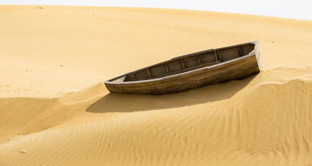 沙漠中搁浅的空木船图片下载