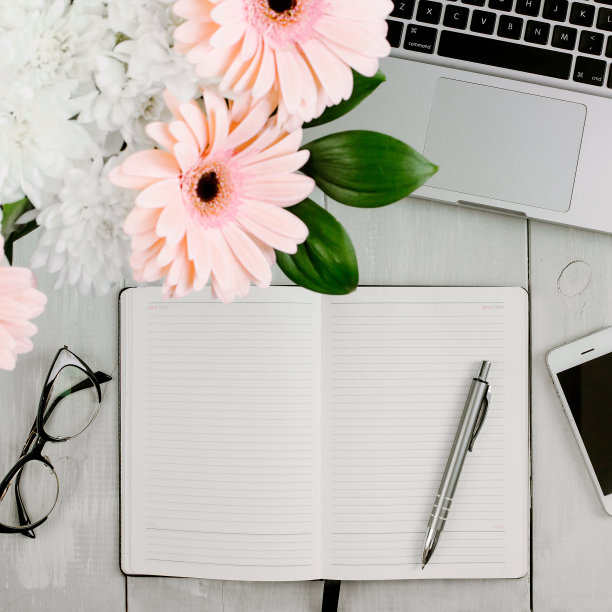 方形图片的家庭工作空间与笔记本电脑，眼镜，打开笔记本，笔在白色木制书桌上。平躺，俯视视图图片下载