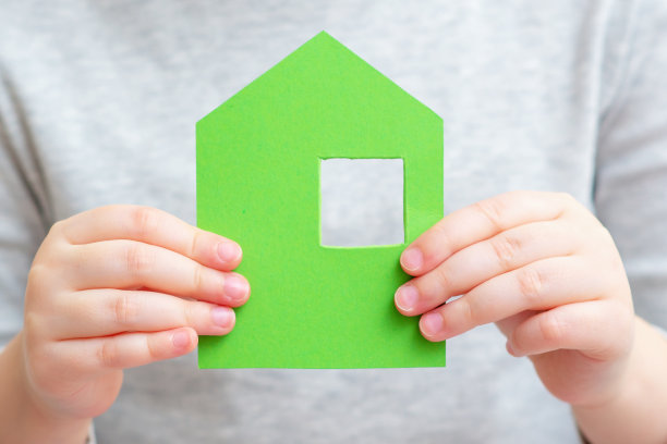 孩子手里拿着小纸房子。图片下载