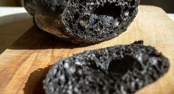 黑面包放在木板和桌子上。以上是健康面包的观点。奇怪的食物。图片下载