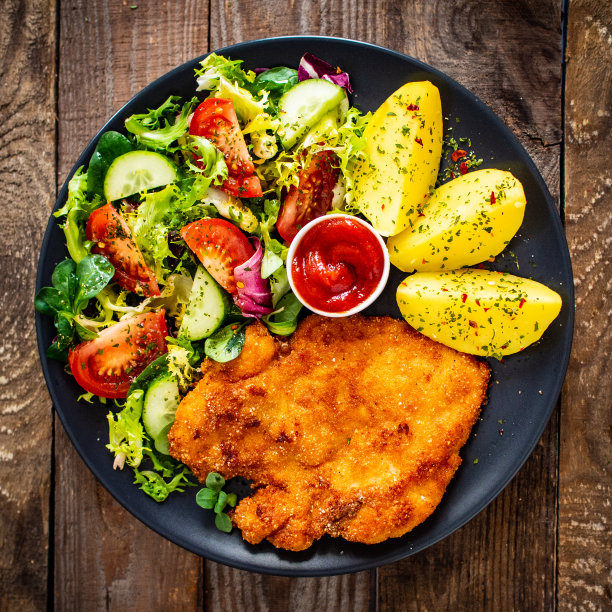 炸猪排、煮土豆和蔬菜沙拉图片下载