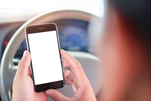 司机在开车时使用手机。圆角的现代智能手机。隔离屏幕模型。汽车导航显示在背景。图片下载