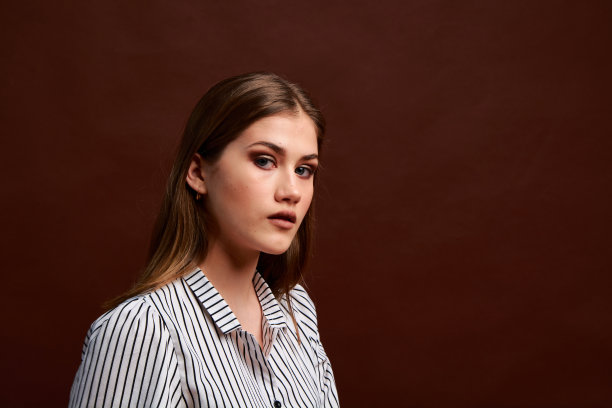 漂亮的年轻女性，穿着经典的套装，黑色的鞋子和灰色的外套。古董椅子。女人的衣服。图片下载