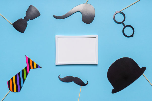 各种黑色的照相亭道具和蓝色背景上的白色空相框。父亲节贺卡，阳刚概念。平铺，复制空间，模拟图片下载